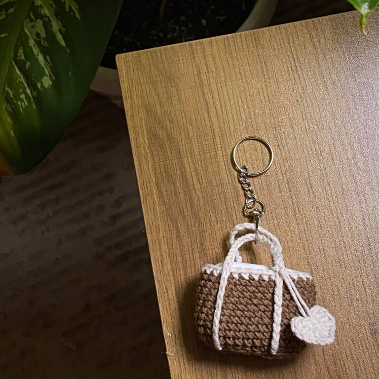 ميدالية مفاتيح كروشيه – تصميم حقيبة يد صغيرة بنية ووردة بيضاء